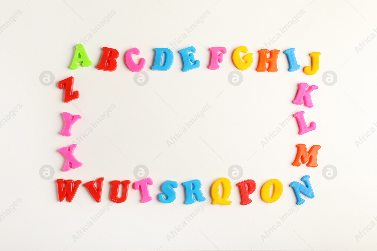 Photo of Frame of colorful magnetic letters on white background, flat lay with space for text. Alphabetic order