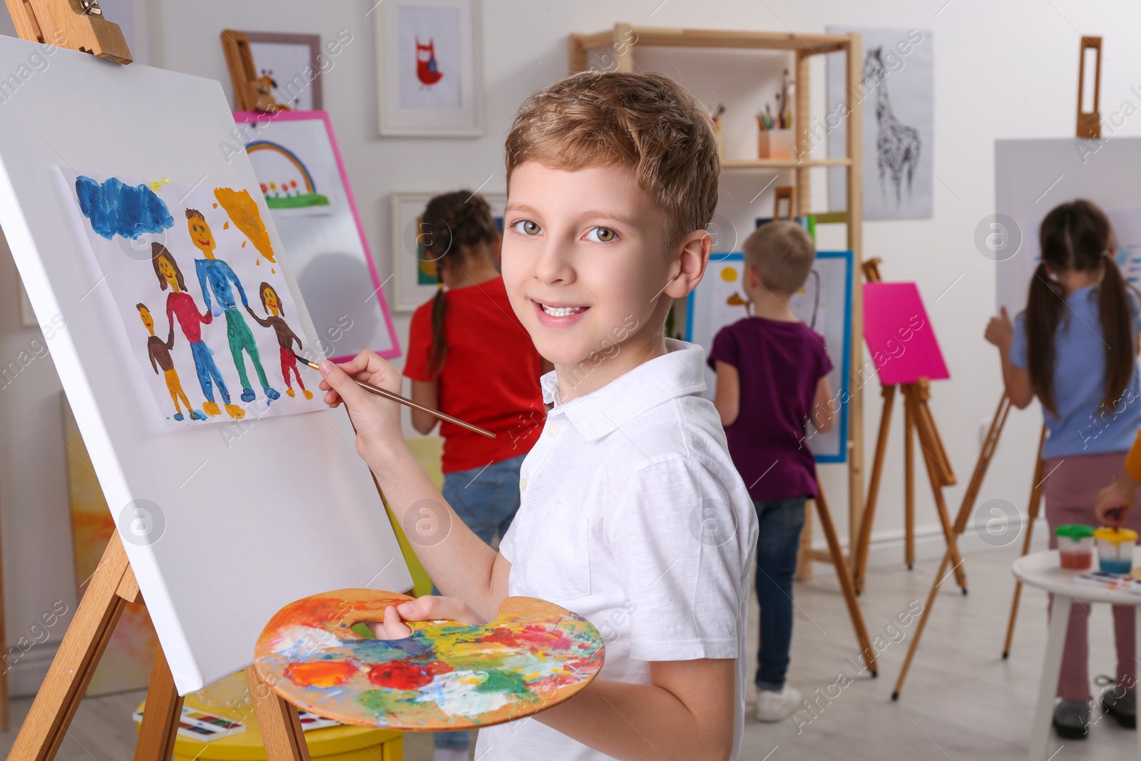 Photo of Cute little child painting during lesson in room