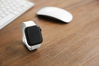 Image of Stylish smart watch on wooden table. Space for text