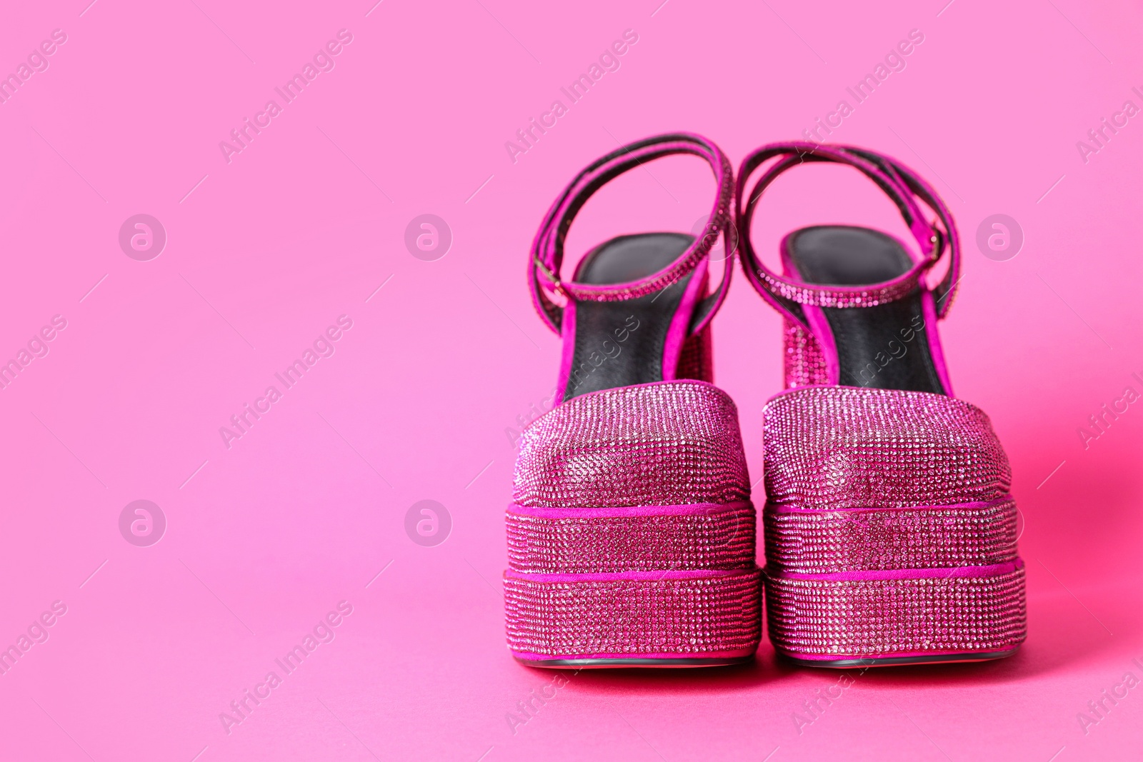 Photo of Fashionable punk square toe ankle strap pumps on pink background, space for text. Shiny party platform high heeled shoes