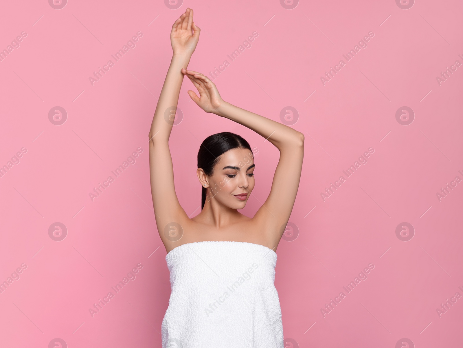 Photo of Young woman showing smooth skin after epilation on pink background