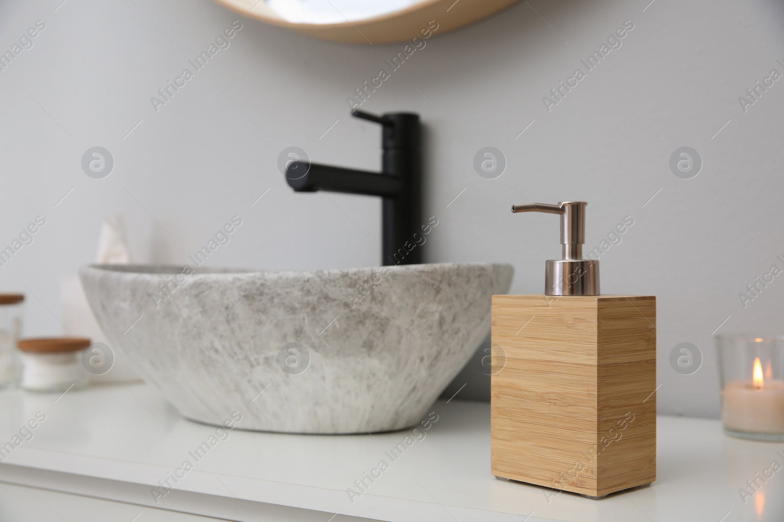 Photo of Wooden dispenser of liquid soap near sink in bathroom. Space for text