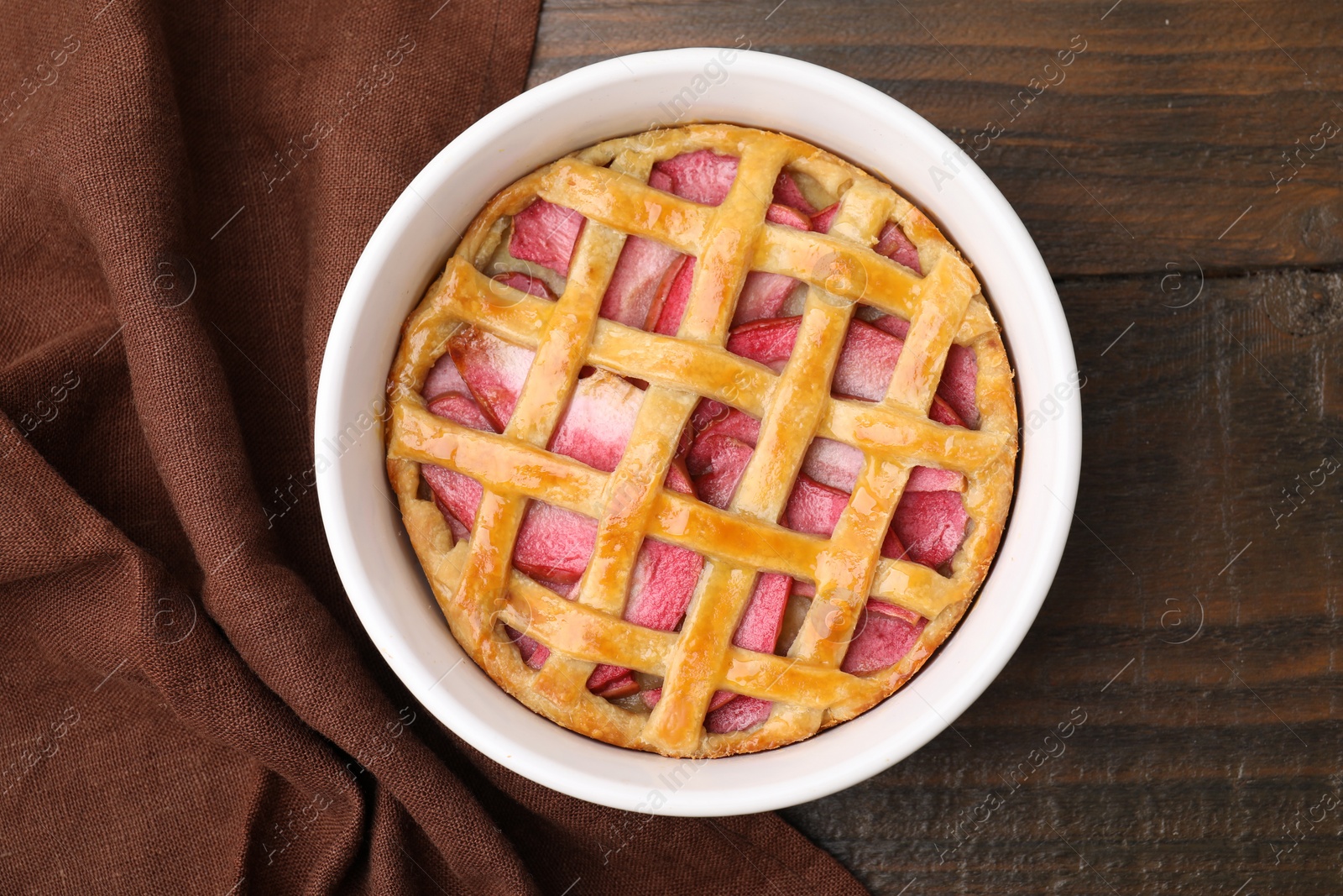 Photo of Baking dish with tasty apple pie on wooden table, top view