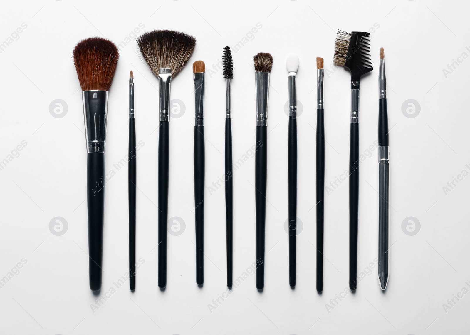 Photo of Different makeup brushes on white background, flat lay