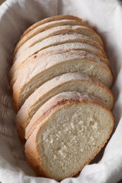 Slices of fresh bread on cloth in basket, above view