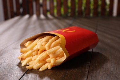 MYKOLAIV, UKRAINE - AUGUST 12, 2021: Big portion of McDonald's French fries on wooden table, closeup