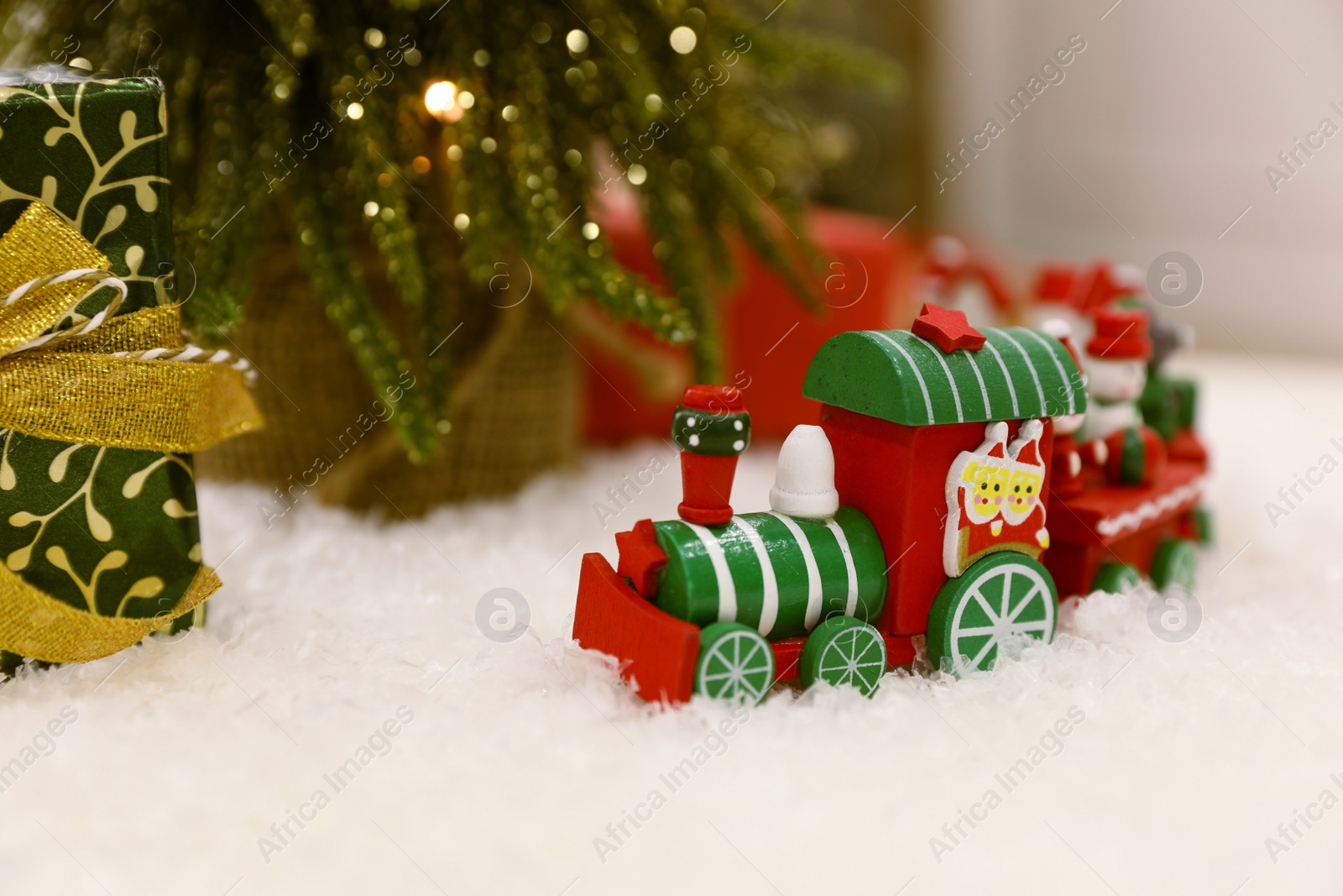 Photo of Bright toy train on artificial snow. Christmas atmosphere