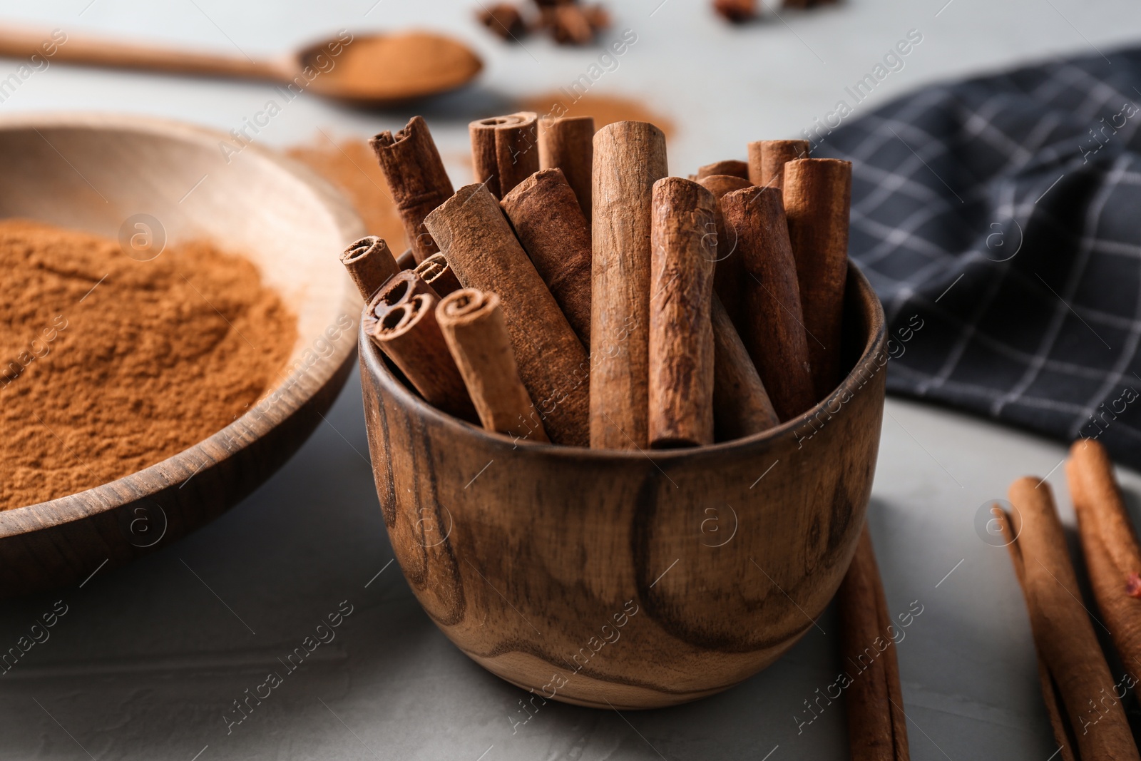 Photo of Bowl with aromatic cinnamon sticks on table