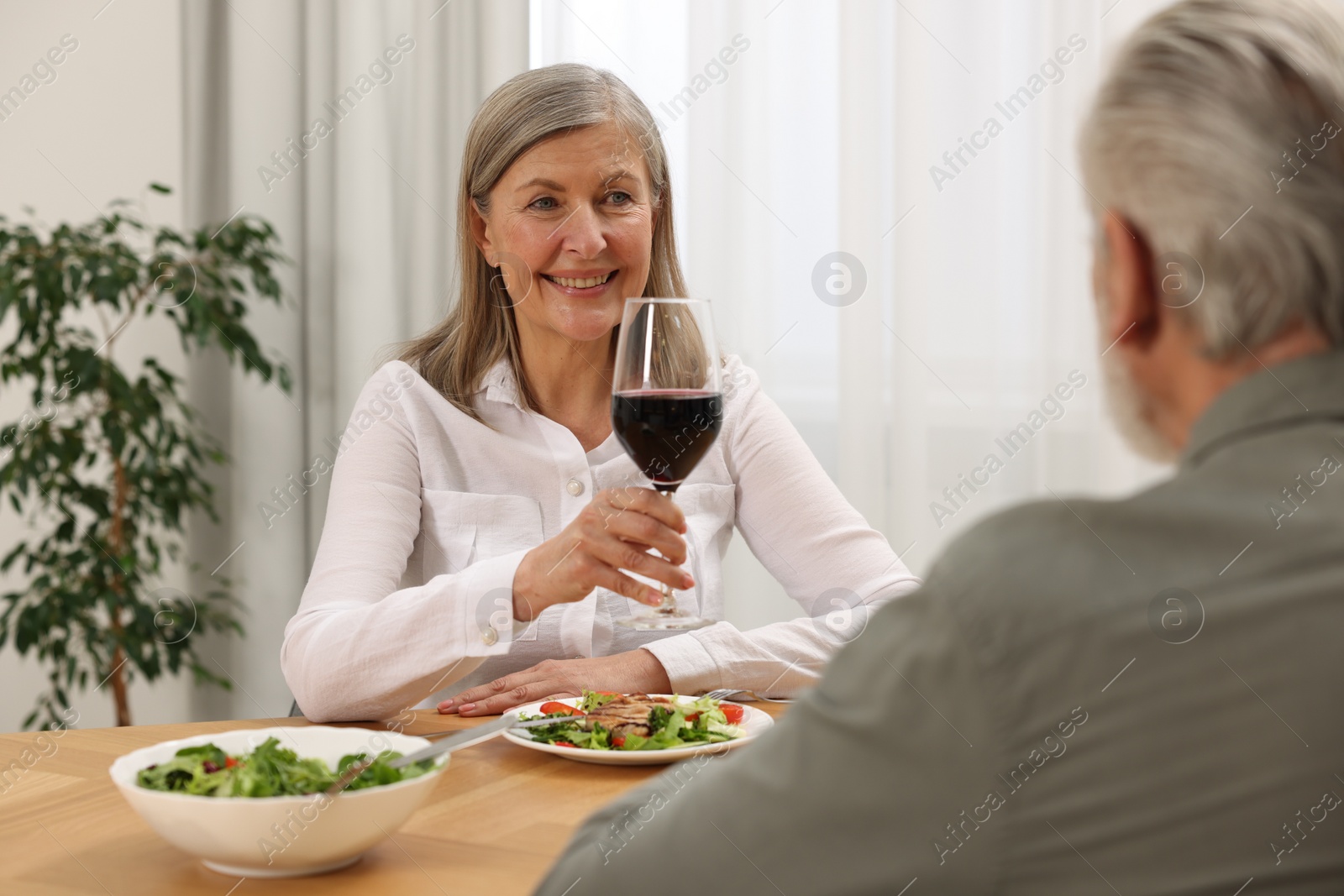 Photo of Happy senior couple having romantic dinner at home