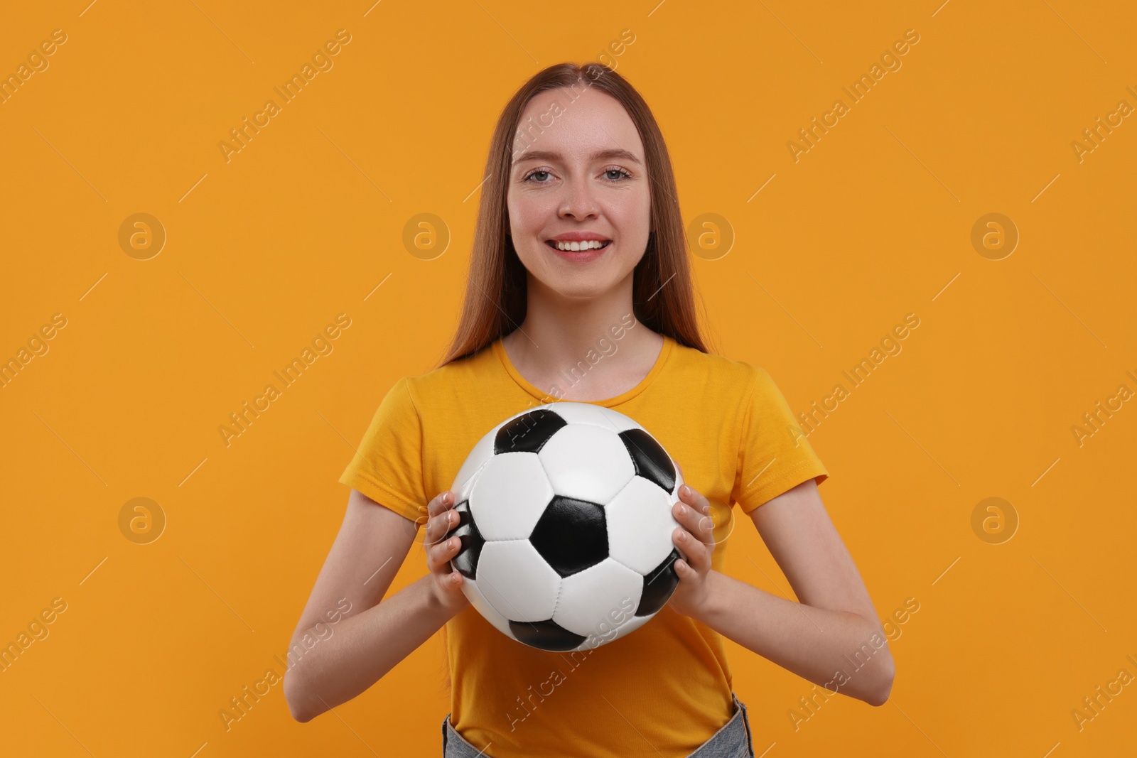 Photo of Happy sports fan with ball on yellow background