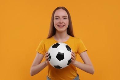 Happy sports fan with ball on yellow background