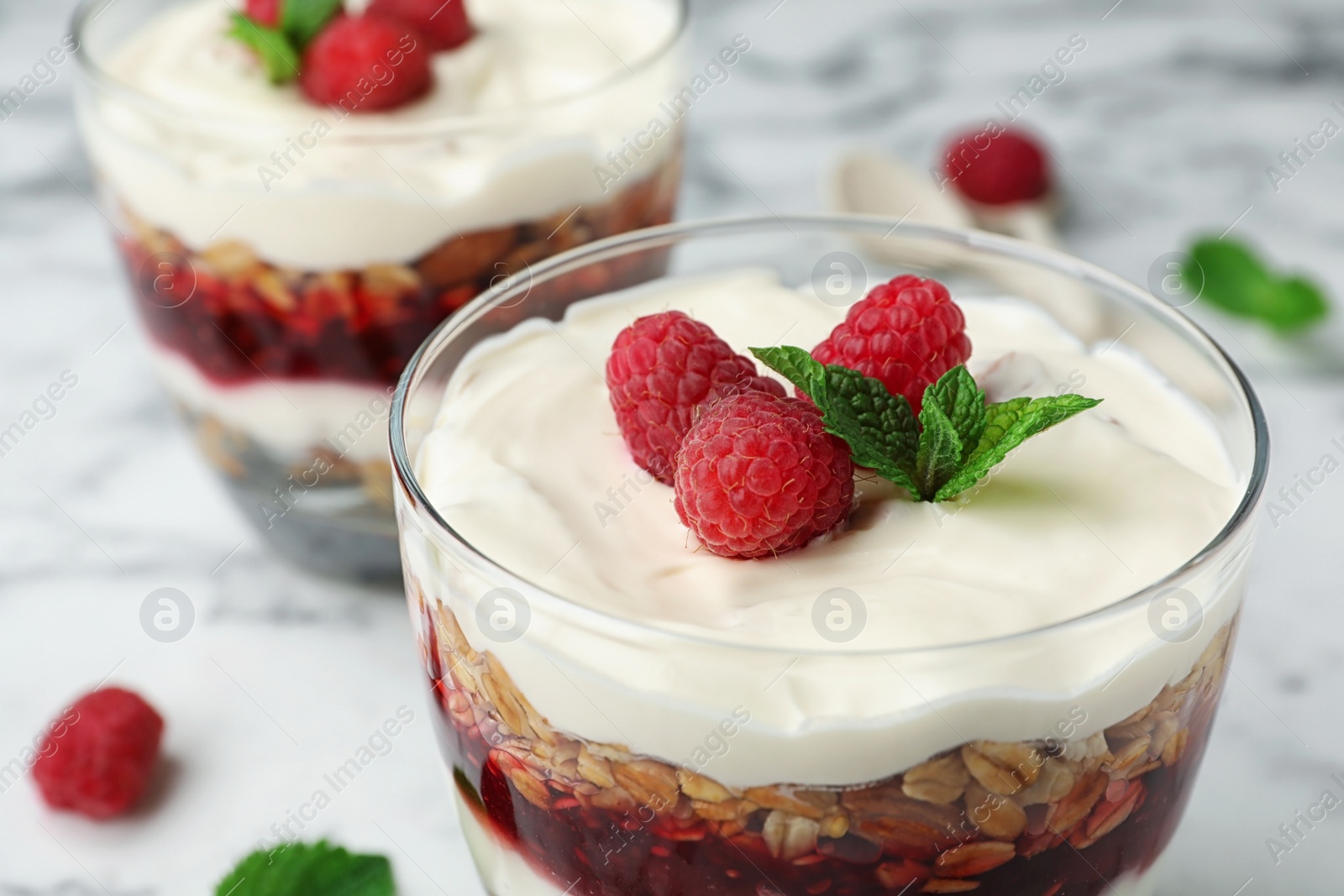 Photo of Delicious oatmeal dessert with raspberries in glass, closeup