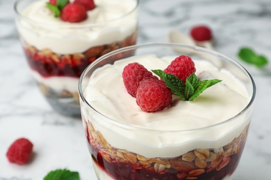 Photo of Delicious oatmeal dessert with raspberries in glass, closeup