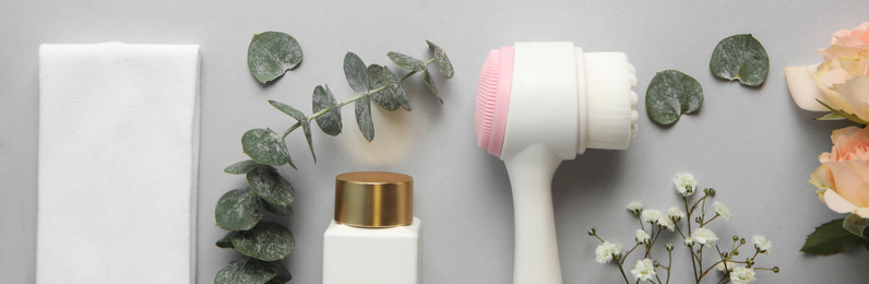 Image of Flat lay composition with face cleansing brush on light grey background, banner design. Cosmetic accessory