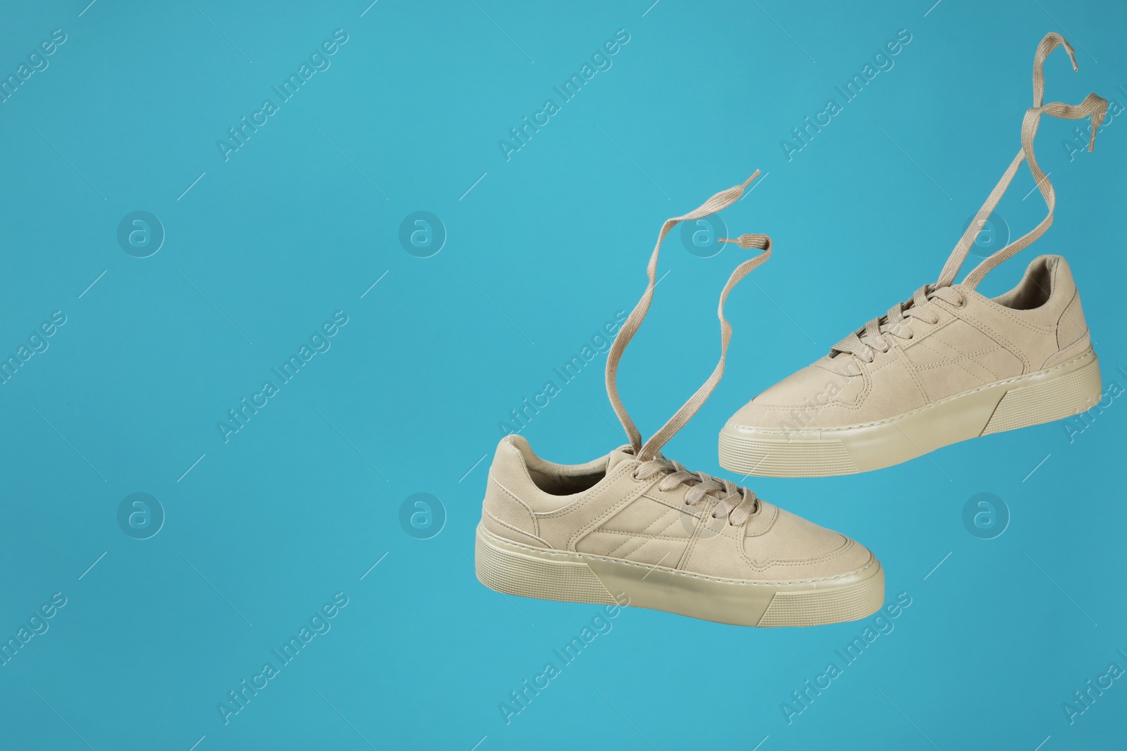 Photo of Pair of stylish white sneakers on blue background, space for text