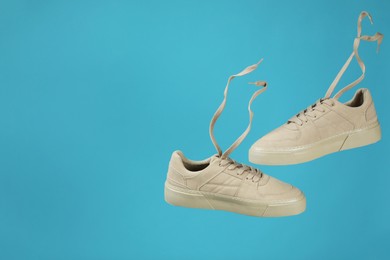 Pair of stylish white sneakers on blue background, space for text