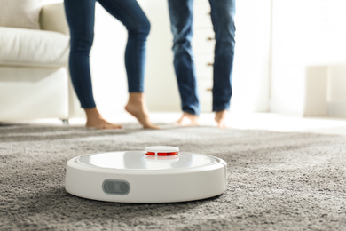 Photo of Couple using robotic vacuum cleaner at home