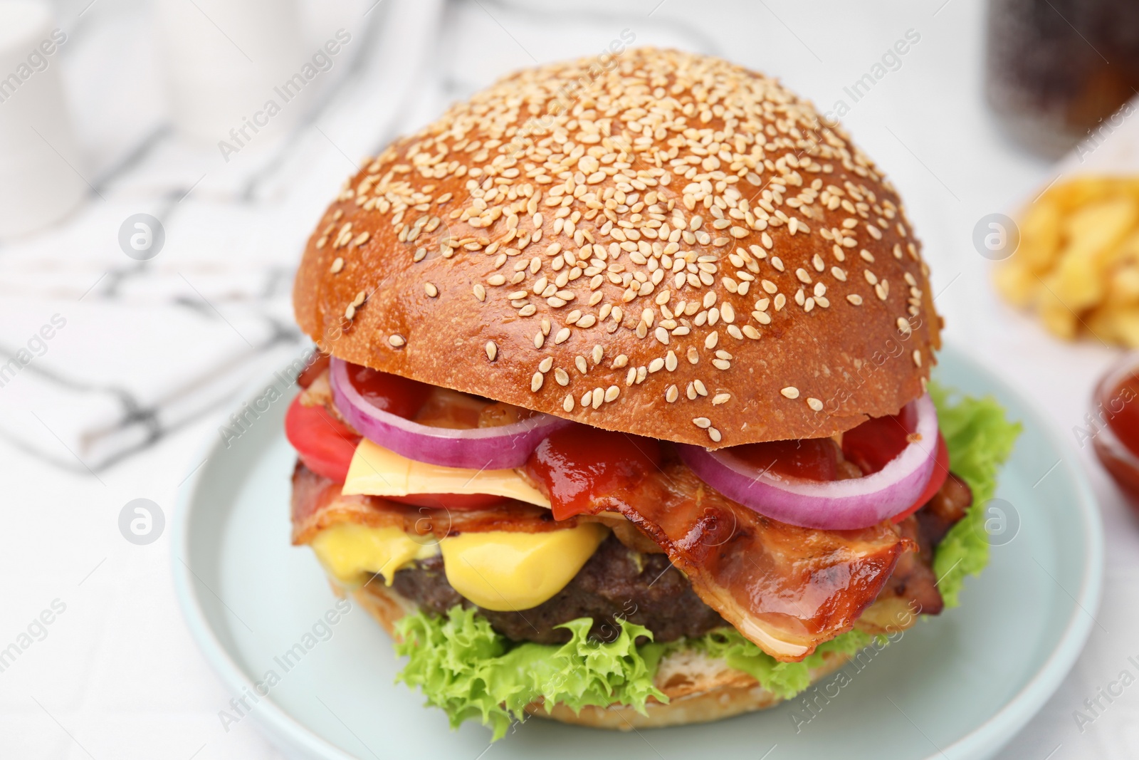 Photo of Delicious burger with bacon, patty and vegetables on white table, closeup