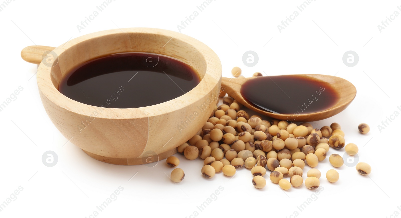 Photo of Tasty soy sauce in bowl, soybeans and spoon isolated on white