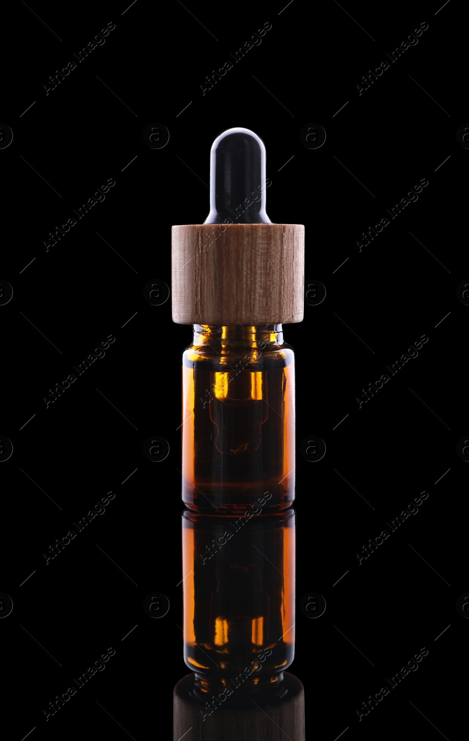 Photo of One brown bottle with tincture on mirror surface against black background