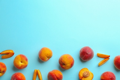 Flat lay composition with fresh peaches on blue background. Space for text