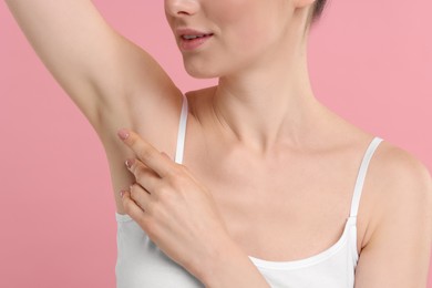Photo of Woman showing armpit with smooth clean skin on pink background, closeup