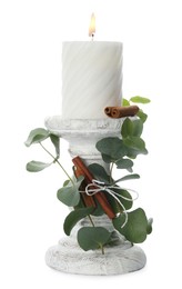 Photo of Decorative candle with leaves and cinnamon sticks isolated on white