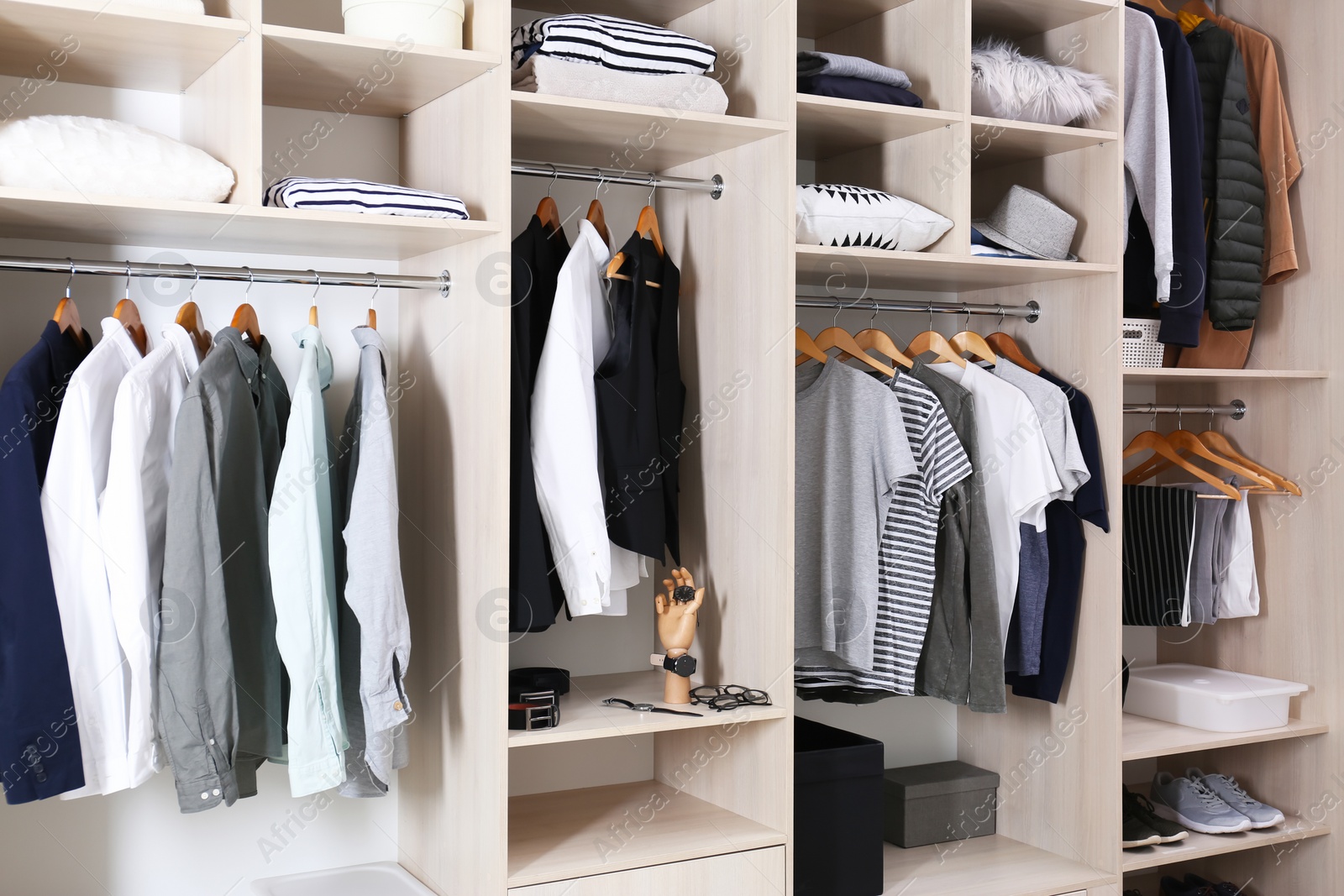 Photo of Stylish clothes, shoes and home stuff in large wardrobe closet