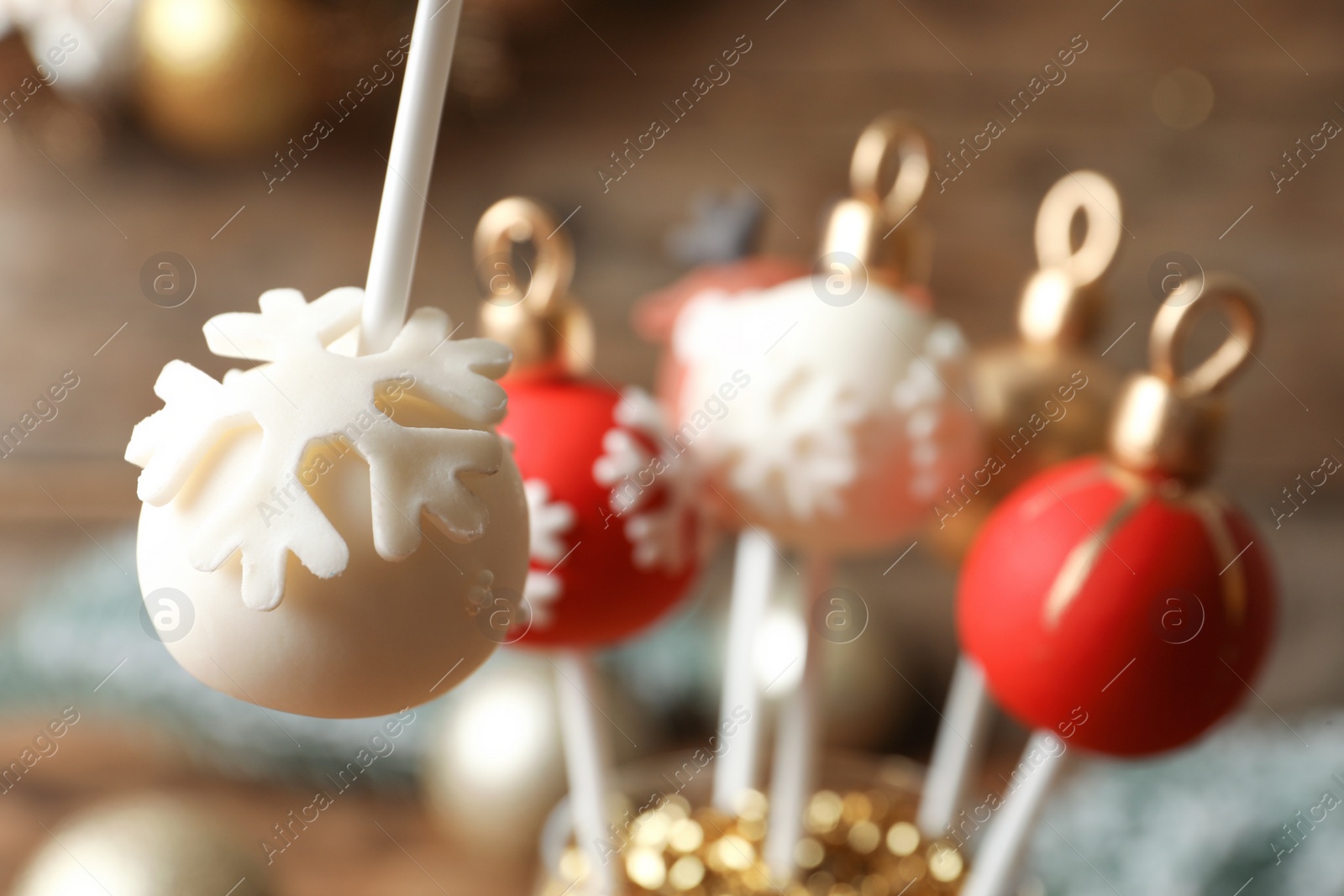 Photo of Delicious Christmas ball cake pop on blurred background, closeup
