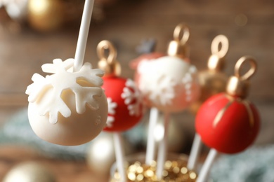 Delicious Christmas ball cake pop on blurred background, closeup