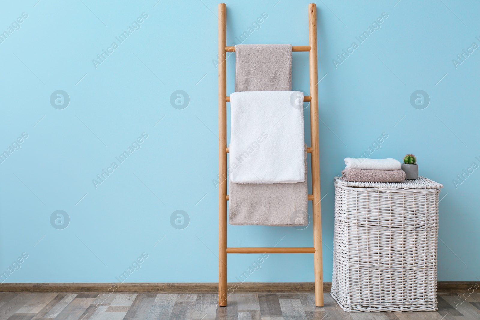 Photo of Clean towels on holder and wicker basket in bathroom