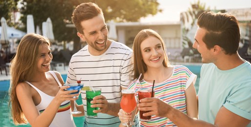 Image of Happy young friends with fresh summer cocktails relaxing near swimming pool. Banner design