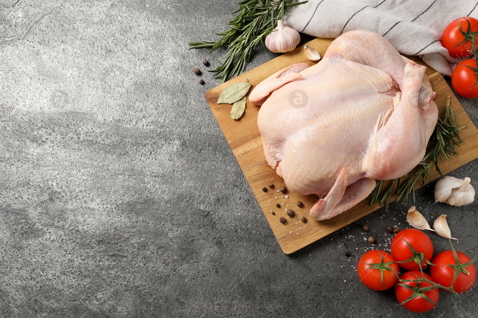 Photo of Fresh raw chicken with spices and vegetables on grey textured table, flat lay. Space for text