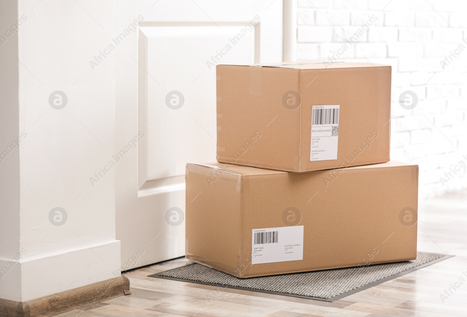 Photo of Parcels on rug near door. Delivery service