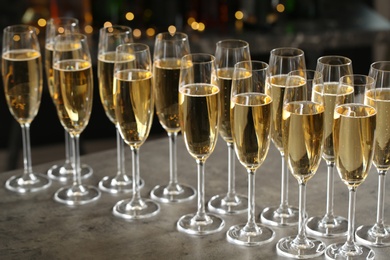 Photo of Glasses of champagne on table against blurred background