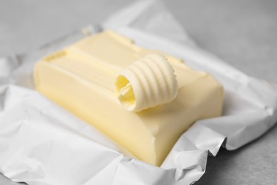 Photo of Tasty butter and curl on light grey table, closeup