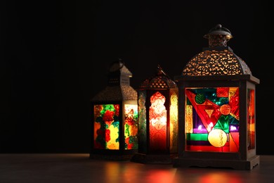 Photo of Decorative Arabic lanterns on table against dark background