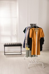 Photo of Rack with stylish women's clothes in dressing room