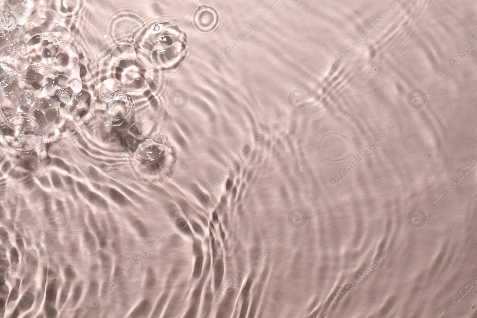 Photo of Rippled surface of clear water on beige background, top view