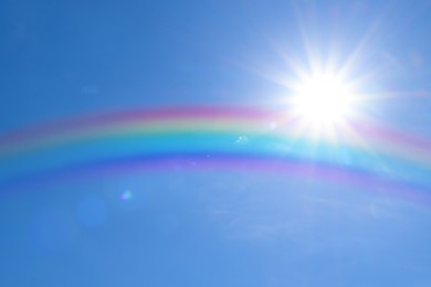 Image of Beautiful view of bright rainbow in blue sky on sunny day