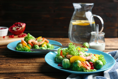 Photo of Tasty salad with Brussels sprouts served on wooden table