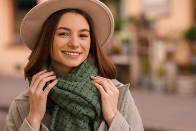 Photo of Beautiful woman in warm scarf and hat outdoors