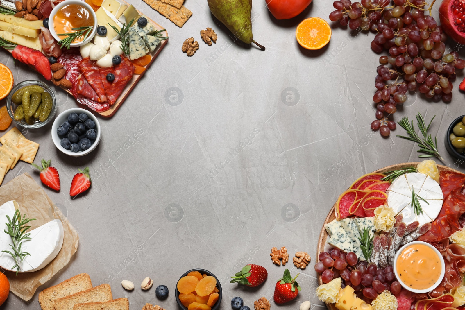 Photo of Frame of different delicious snacks on grey table, flat lay. Space for text