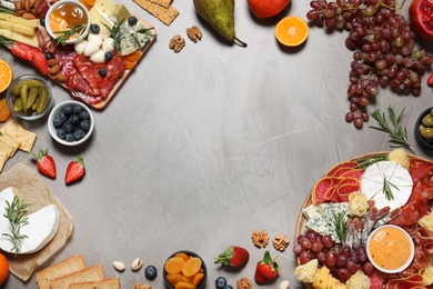 Photo of Frame of different delicious snacks on grey table, flat lay. Space for text