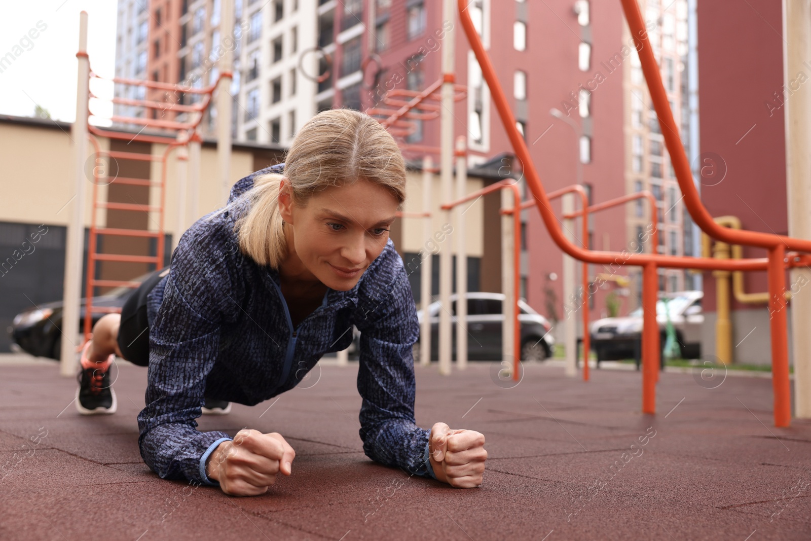 Photo of Woman doing plank exercise at outdoor gym, space for text
