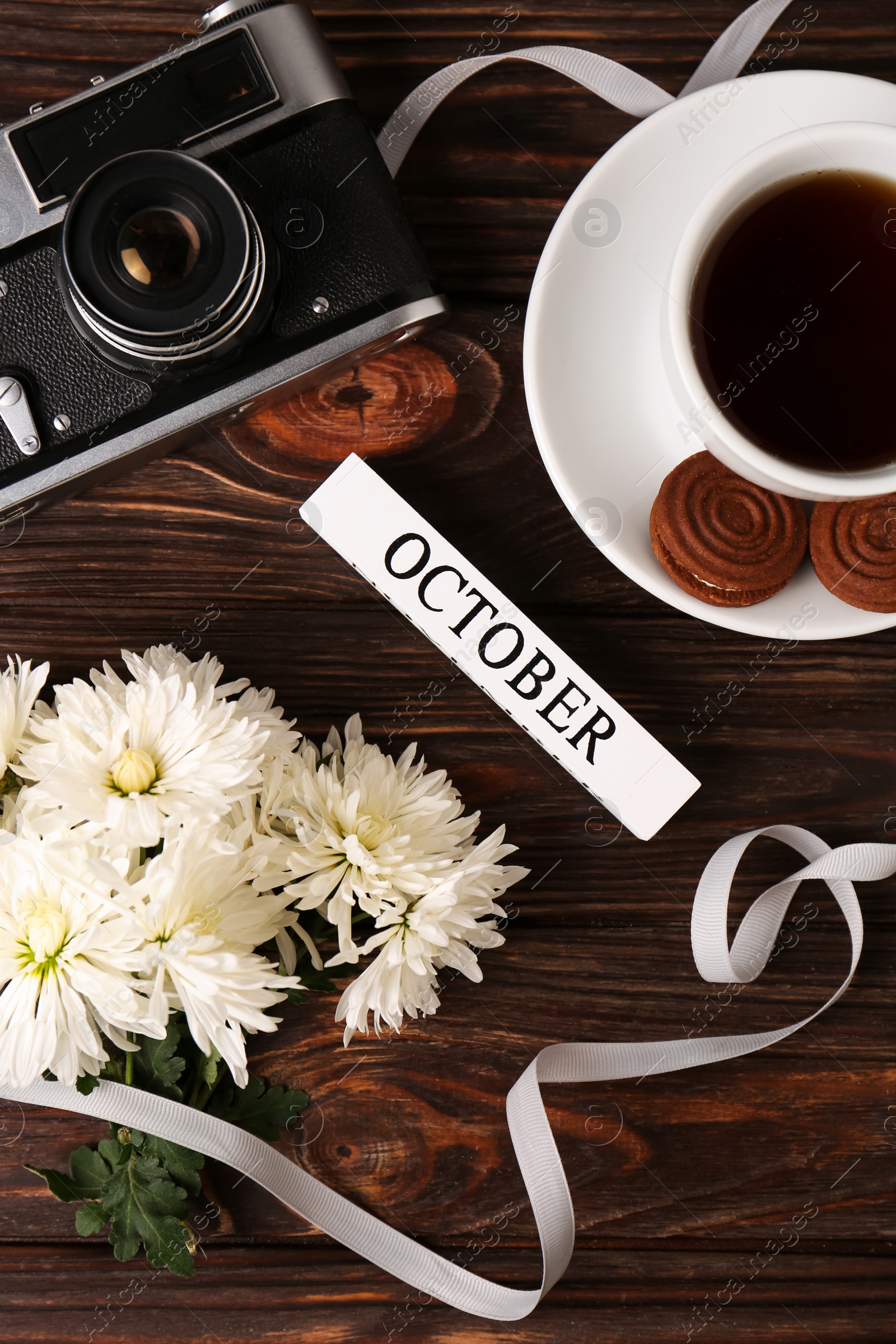 Photo of Flat lay composition with beautiful white chrysanthemum flowers and vintage camera on wooden table