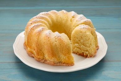 Photo of Delicious freshly baked sponge cake on light blue wooden table, closeup