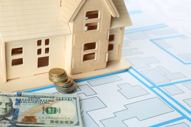 Photo of Money and house model on cadastral map, closeup