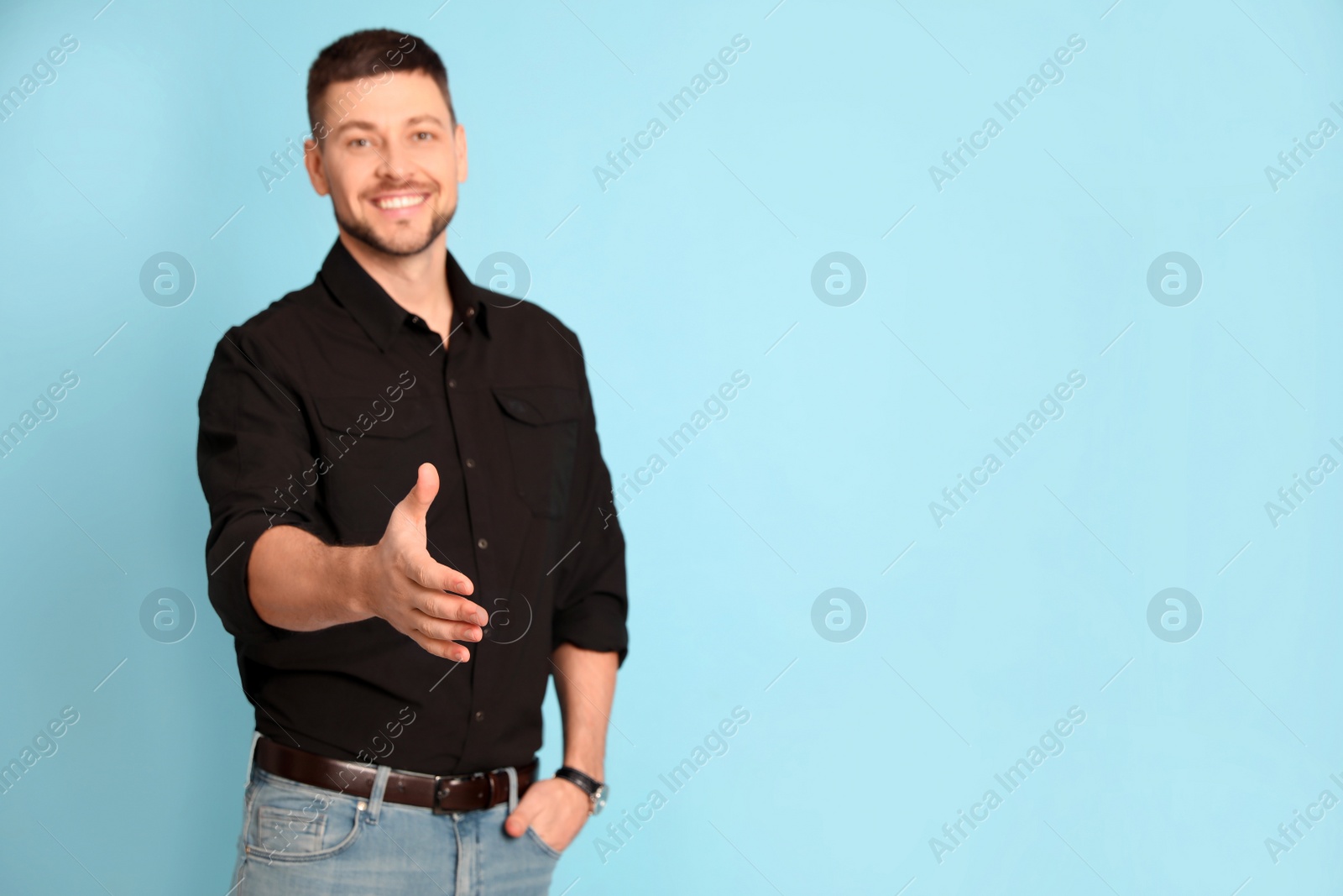 Photo of Businessman offering handshake against turquoise background, focus on hand. Space for text