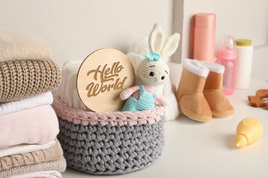 Baby clothes, toy and accessories on white table